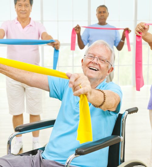 Mature Adults and a Disabled Person Exercising in a Gym